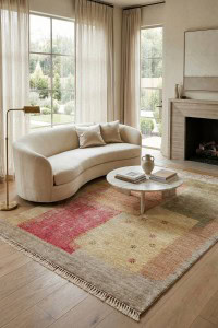 Ugaona sofa u dnevnom boravku s velikim prozorima i prirodnim svjetlom, postavljena na moderni tepih u bež i crvenim tonovima, idealna za udobno i elegantno uređenje doma.