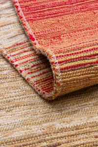 DAPHNE, Kutnu tepih od prirodnih boja, ručno izrađen od tradicionalnih tkanina s bogatim crvenim, žutim i narančastim nijansama, prikazan na web stranici.