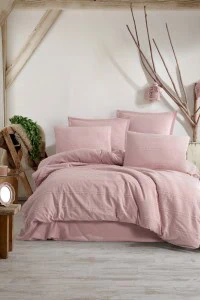 Umetnički prikaz posteljine Avola V4 (Roza) - 100% pamuk, boho stil sa teksturom, u svijetloj roza boji, u modernom i udobnom prostoru s prirodnim elementima i dekoracijom od grana.