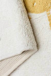 DAPHNE, antialergijski dječiji tepih od pamuka u krem boji, prikazan u blizini žutog i bijelog podnog pokrivača, idealan za osjetljivu dječju kožu i siguran za alergične.