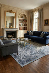 Umetni tepih Fresco plavi u elegantnom dnevnom boravku s klasičnim dekorom, drvenim podom i velikim prozorima, savršen za luksuzni interijer.