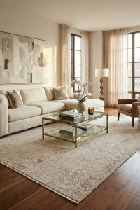 Umetni tepih u modernu dnevnu sobu sa prirodnim svjetlom, bežnim tonovima i elegantnim dekorom, ističući ekskluzivnu kolekciju Tepih Mahal Mood - Beige (MHL04).