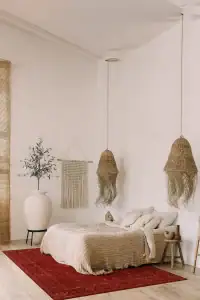 DAPHNE, tepih Shiraz crveni boje u spavaćoj sobi sa minimalističkim dekorom, prirodnim materijalima i toplim tonovima, idealan za elegantan i udoban enterijer.